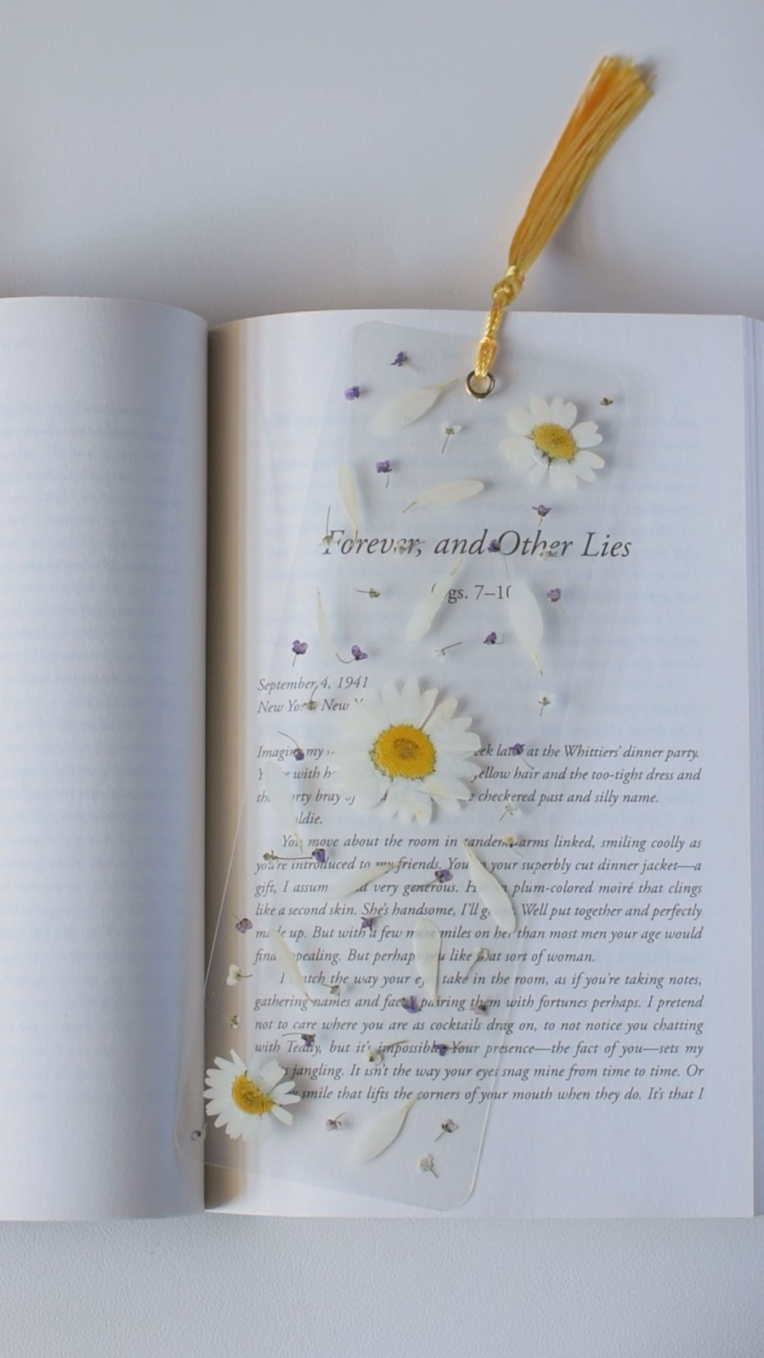 Video de separador de libros transparente con flores prensadas en su interior de color blanco.